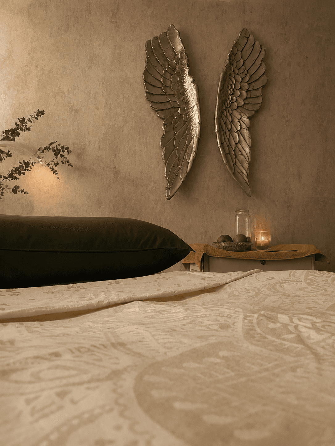 Nurture Body Therapy treatment room — botanical-print bedding, soft morning light, calm neutral tones. Ashford, Kent.